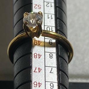 Park Lane gold toned, thin band ring with prong set clear stone, size 4.75